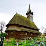 Biserica tradițională de lemn din Maramureș împodobită pentru sărbătorile pascale cu flori de primăvară