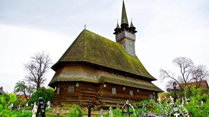 Vacanțe de Paște în România – Destinații de neuitat pentru familii și cupluri în 2026 1 Biserica tradițională de lemn din Maramureș împodobită pentru sărbătorile pascale cu flori de primăvară