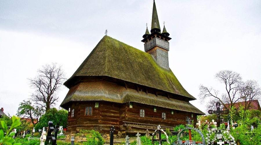 Biserica tradițională de lemn din Maramureș împodobită pentru sărbătorile pascale cu flori de primăvară