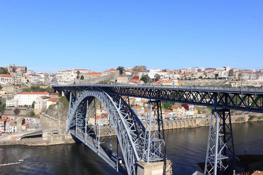 Podul Dom Luis I Porto la apus cu râul Douro și clădiri colorate Ribeira