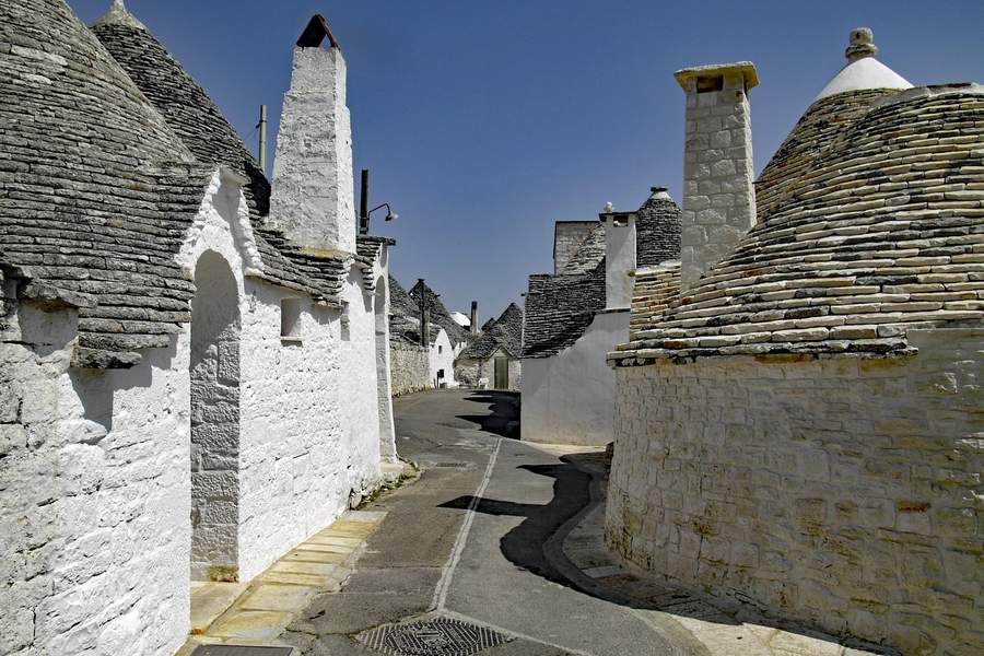 Puglia în 2026: De ce „Tocul Cizmei" Italiei este noua destinație de vis pentru călătorii autentici 3 Casele tradiționale trulli cu acoperișuri conice din piatră uscată în Alberobello, sit UNESCO, Puglia